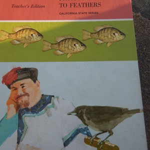 Puede incluir: Una portada de libro vintage con el título "From Fins to Feathers" y las palabras "Teacher's Edition" y "California State Series". La portada presenta ilustraciones de tres peces y un pájaro.