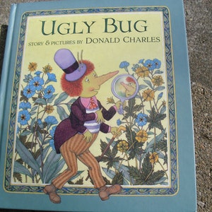 Puede incluir: Una portada de libro con fondo azul y borde amarillo. El título es "Ugly Bug" con las palabras "Story & Pictures by Donald Charles" debajo. La portada presenta una ilustración de un bicho con una nariz grande, un sombrero morado y una lupa.