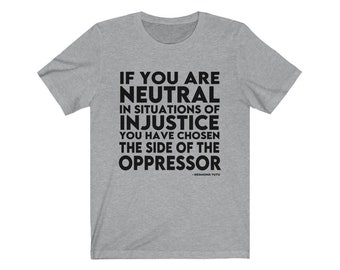 May include: A gray t-shirt with a black quote that reads "If you are neutral in situations of injustice you have chosen the side of the oppressor - Desmond Tutu".