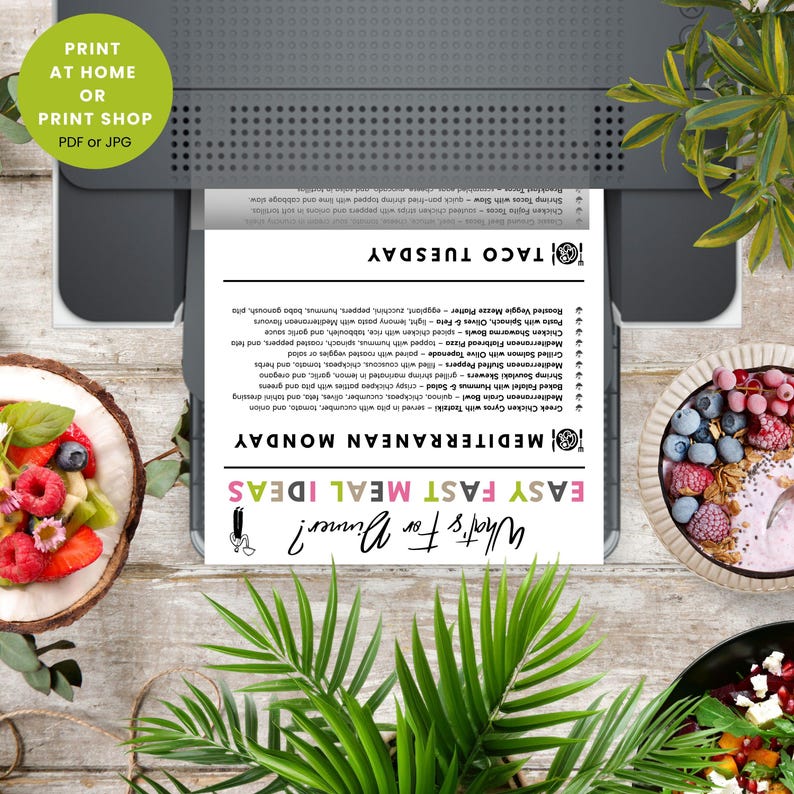Op de afbeelding: Een gedrukt menu met de tekst "What's For Dinner?" en "Easy Fast Meal Ideas." Het menu bevat "Mediterranean Monday" en "Taco Tuesday" maaltijdopties. De afbeelding bevat een printer en voedselkommen.