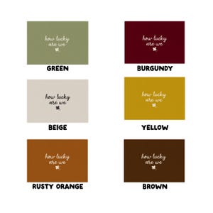 May include: A collection of six rectangular cards in various colors: green, burgundy, beige, yellow, rusty orange, and brown. Each card features the phrase "how lucky are we" in a handwritten style, along with a small clover graphic.