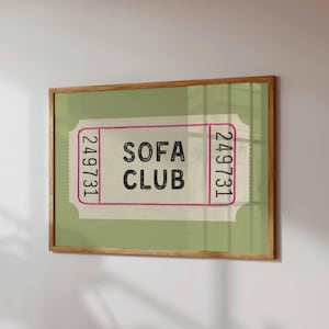 May include: A framed print featuring a vintage-style ticket design. The ticket has a light green background with the words "SOFA CLUB" in bold black letters. The ticket's edges are outlined in pink, with the number "249731" printed on each end.