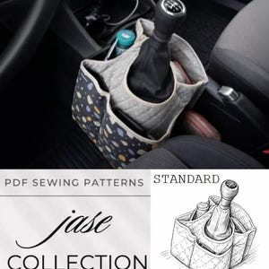 May include: A car console organizer with multiple pockets, featuring a black gear shift. The organizer is made of fabric with a pattern of blue, yellow, and white shapes on a dark background. The text "jase COLLECTION" is visible.