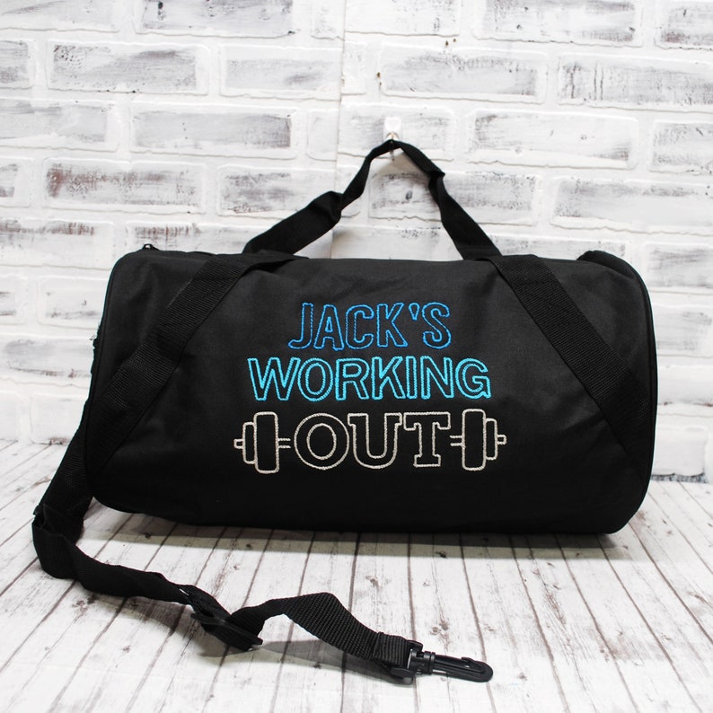 May include: Black duffel bag with a blue and white embroidered design that says "Jack's Working Out" with a dumbbell graphic.