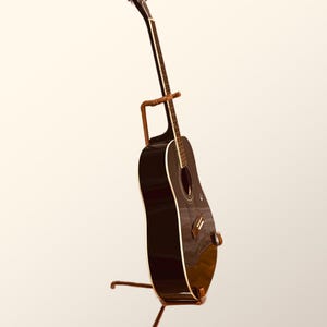 May include: A black acoustic guitar with a wooden stand. The guitar has a natural wood finish on the back and sides.