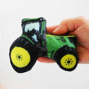 Può includere: Trattore di peluche verde e nero con ruote gialle. Il trattore ha un design dettagliato ed è perfetto per la collezione di giocattoli di un bambino.