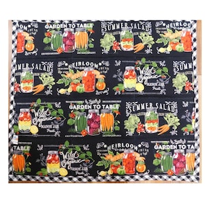 May include: Black and white checkered kitchen mat with a repeating pattern of mason jars filled with vegetables and fruits. The mat has text that reads "Garden to Table", "Summer Salad", and "Heirloom Fresh".