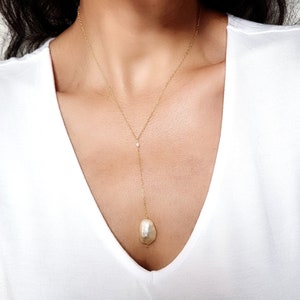 Y necklace with a tiny pearl and large white pearl hanging on the bottom