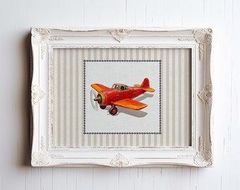 May include: A framed print of a red toy airplane with a white propeller and yellow accents. The print is on a striped background.