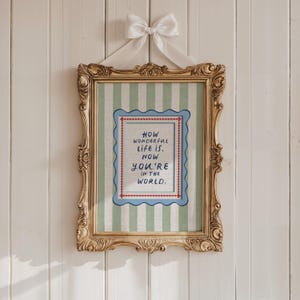 A timeless How Wonderful Life Is Now You’re In the World nursery print in soft sage green tones with classic stripes and a vintage circus feel. Perfect for playroom wall art, kids wall art, and baby room wall decor. This heartfelt nursery quote print adds warmth and meaning to any space, pairing beautifully with sage green nursery art and traditional circus nursery themes. Ideal for parents who love vintage playroom art and storybook-inspired design.