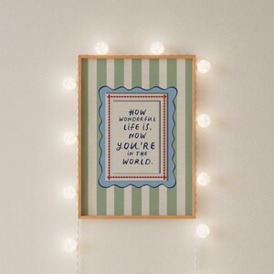 A vintage-inspired How Wonderful Life Is Now You’re In the World nursery print designed in soft sage green with playful stripes and a wavy frame. Perfect as kids wall art, playroom wall art, or part of a whimsical circus nursery theme. This timeless design brings warmth and storybook charm to baby rooms and makes a thoughtful gift for new parents. A beautiful piece of sage green nursery art for classic, character-filled interiors.