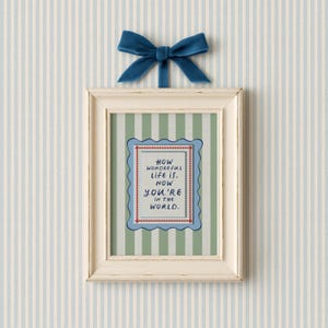 A vintage-inspired How Wonderful Life Is Now You’re In the World nursery print in soft sage green stripes — a beautiful affirmation for children and a perfect DIY nursery art idea. This positive quote print encourages joy and self-worth while adding warmth to any playroom or baby room. Ideal for parents creating mindful kids spaces, handmade playroom wall art, or sage green nursery decor with a storybook, circus-inspired touch.