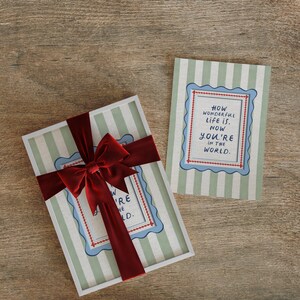 A timeless How Wonderful Life Is Now You’re In the World nursery print in soft sage green tones with classic stripes and a vintage circus feel. Perfect for playroom wall art, kids wall art, and baby room wall decor. This heartfelt nursery quote print adds warmth and meaning to any space, pairing beautifully with sage green nursery art and traditional circus nursery themes. Ideal for parents who love vintage playroom art and storybook-inspired design.