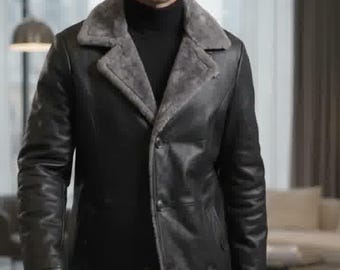 May include: A black leather coat featuring a wide, grey faux-fur lapel collar and a button-front closure. The coat is worn over a black turtleneck sweater, providing a layered look with a smooth, dark exterior finish and a soft, textured interior lining.