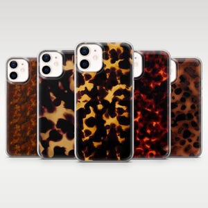 以下が含まれることがあります： 茶色、黒、黄色の色合いのべっ甲模様の携帯電話ケース5つ。ケースは透明な縁と光沢のある仕上げで、携帯電話にスタイリッシュで保護的なデザインを提供します。