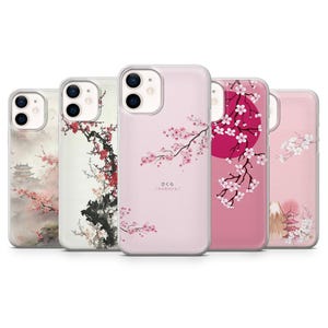 Può includere: Cinque custodie per telefono diverse con un design floreale rosa e bianco. Le custodie presentano un design di ciliegio giapponese con il testo "さくら / sakura" su una delle custodie.