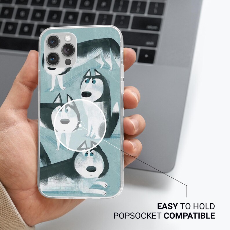 May include: A clear phone case with a blue background and a pattern of four cartoon husky dogs. The dogs are in various poses and have different expressions. The case is compatible with a popsocket.
