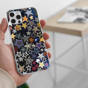 May include: A clear phone case with a colorful star pattern. The stars are various colors, including yellow, blue, silver, and red, and are arranged on a dark blue background. The case has a clear border and a camera cutout.
