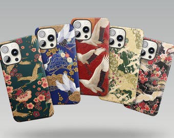 Peut inclure: Cinq coques de smartphone arborant des motifs complexes de grues blanches, de pins et de fleurs rouges ou roses. Les coques sont disposées en éventail, chacune avec une couleur de fond distincte, notamment vert foncé, bleu, rouge, beige et noir.