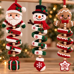 May include: Three crochet Christmas ornaments hanging from a wooden bar. The left is a Santa Claus with a gift, the center is a snowman with a mitten, and the right is a gingerbread person with a star. Each features a spiral body with wooden beads.