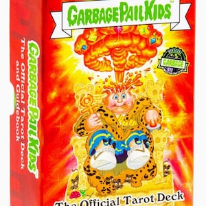 May include: A red box featuring "GARBAGE PAIL KIDS" branding. The front displays a cartoon character on a throne with a yellow and orange explosion background. Text reads "The Official Tarot Deck and Guidebook."
