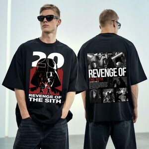 Op de afbeelding: Zwart T-shirt met een grafische print van Darth Vader en de tekst "20 Revenge of the Sith". De achterkant van het shirt heeft een collage van personages uit de film "Star Wars: Revenge of the Sith" met de tekst "Revenge of the Sith".