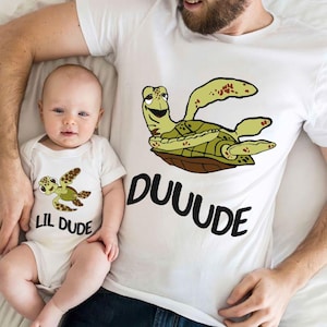 May include: White t-shirts with a cartoon sea turtle design. The adult shirt says "DUUUDE" and the baby shirt says "Lil Dude".