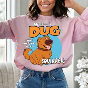May include: Pink sweatshirt with a graphic of Dug the dog from the movie Up. The graphic says "My Name is Dug I just met you and... SQUIRREL!"