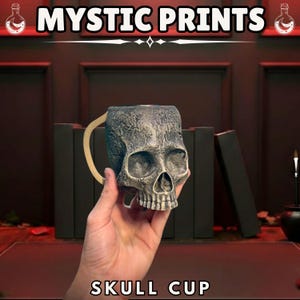 May include: A skull-shaped cup with a handle, held in a hand. The cup is gray and textured, with a detailed skull design. The text "MYSTIC PRINTS" and "SKULL CUP" are displayed in white. The background includes dark books and a red surface.