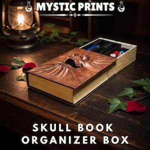 Peut inclure: Une boîte organisateur en forme de livre avec un crâne brun et des bords dorés, ouverte pour révéler des compartiments. Le couvercle présente un motif de crâne détaillé. Le texte "MYSTIC PRINTS" et "SKULL BOOK ORGANIZER BOX" sont visibles.