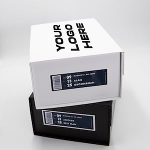 May include: Two stacked shoe boxes, one white and one black. The white box has the text "YOUR LOGO HERE" on the lid. Both boxes have labels with the text "MARCUS'S I DO CREW" and names like "ALAN" and "JACOLBY".