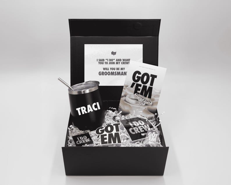 May include: A black gift box containing a black tumbler with "TRACI" in white, a card that says "GOT 'EM", and several stickers. The box also contains a card that says "I SAID 'I DO' AND WANT YOU TO JOIN MY CREW! WILL YOU BE MY GROOMSMAN".