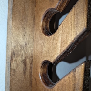 Detail of slot profile with rounded edges on the wooden hat rack.