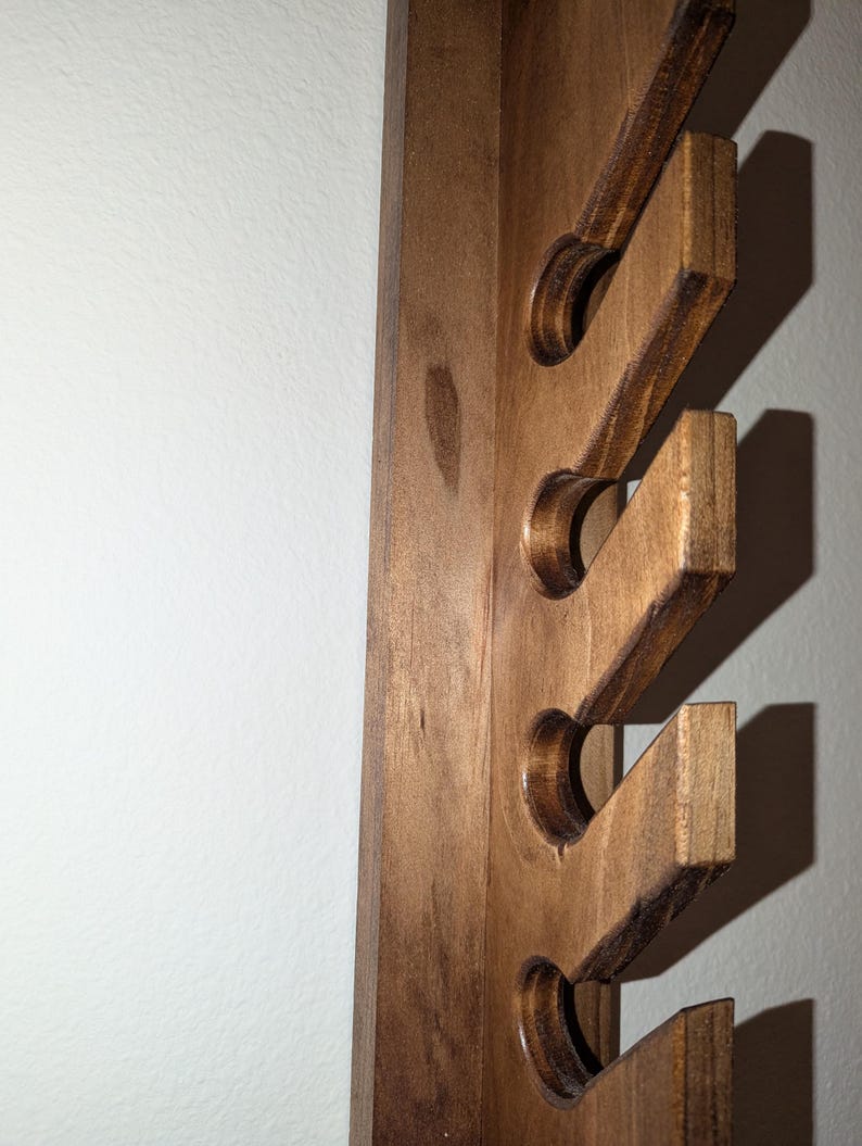Close-up of staggered front slots on the solid-wood hat rack; smooth edges and visible grain.