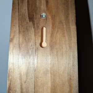 Back of rack showing keyhole mounts and screw for secure wall installation.