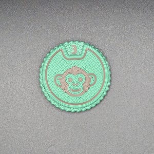 Peut inclure: Un écusson rond vert et marron représentant un visage de singe et le chiffre 3. Le patch présente un motif texturé et un bord festonné. Le visage du singe est marron, sur fond vert.