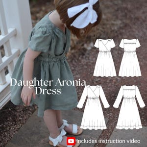May include: A young girl in a sage green dress with a wrap bodice and elasticated waist. She wears white sandals. The image shows a pattern for the "Daughter Aronia Dress" and states "Includes instruction video".