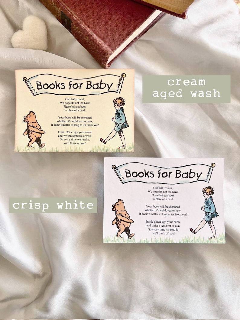 May include: Two cards with a light blue background and white text. The cards have a banner at the top that says "Books for Baby". The cards feature a Winnie the Pooh illustration and a child with a book. The text on the cards asks guests to bring a book instead of a card. The cards are shown on a white surface. One card has a text overlay that says "cream aged wash" and the other card has a text overlay that says "crisp white".