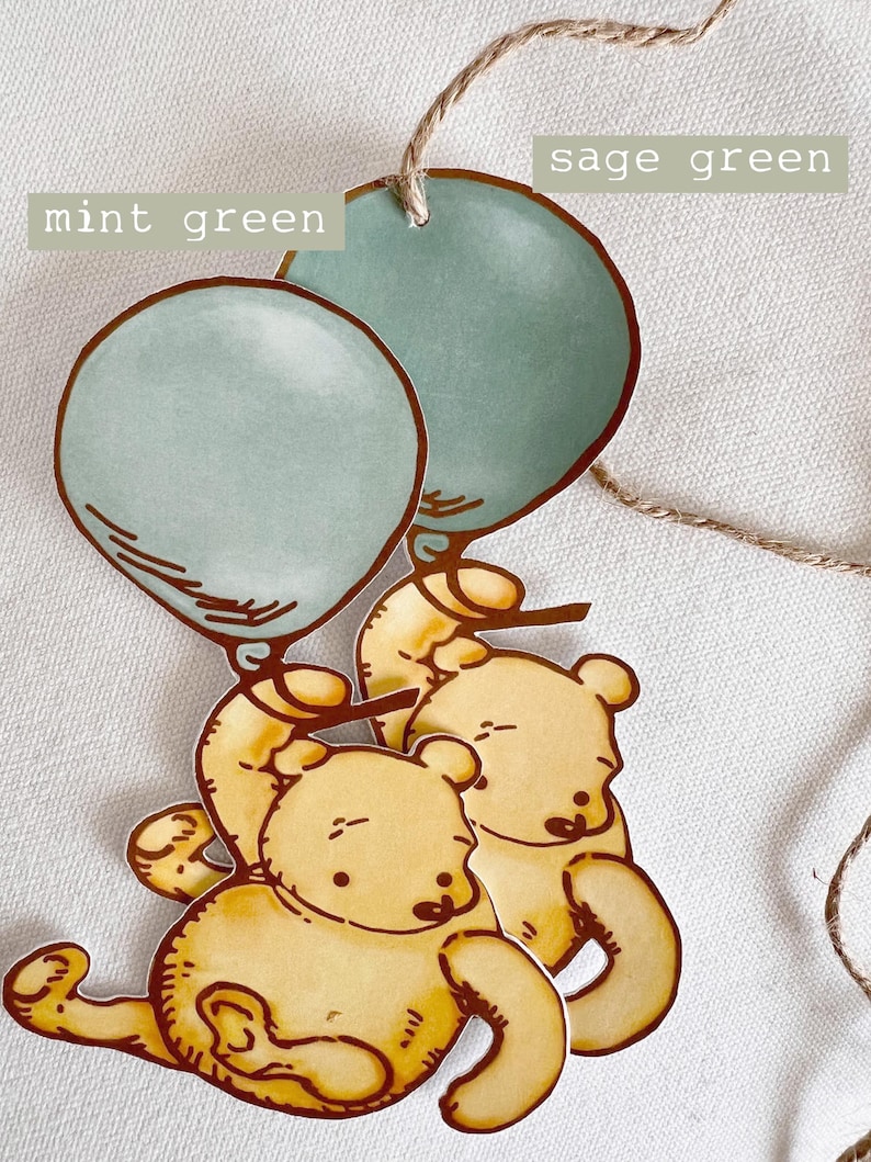 May include: Two yellow cartoon bears holding sage green and mint green balloons. The balloons are tied together with twine.