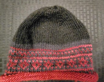 May include: A black knit beanie with a red and gray patterned band.