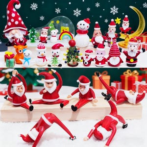 Peut inclure: Une collection de figurines de Noël, dont des Pères Noël dans diverses poses de yoga, des bonhommes de neige, des gnomes et des sapins miniatures. Les figurines sont rouges, blanches et vertes, sur un fond enneigé.
