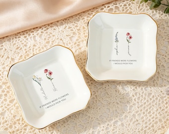 Könnte beinhalten: Zwei quadratische Schmuckschalen aus weißer Keramik mit gewelltem Rand und goldfarbenen Kanten. Jede Schale zeigt eine Blumenillustration, einen personalisierten Namen und den aufgedruckten Text IF FRIENDS WERE FLOWERS I WOULD PICK YOU.