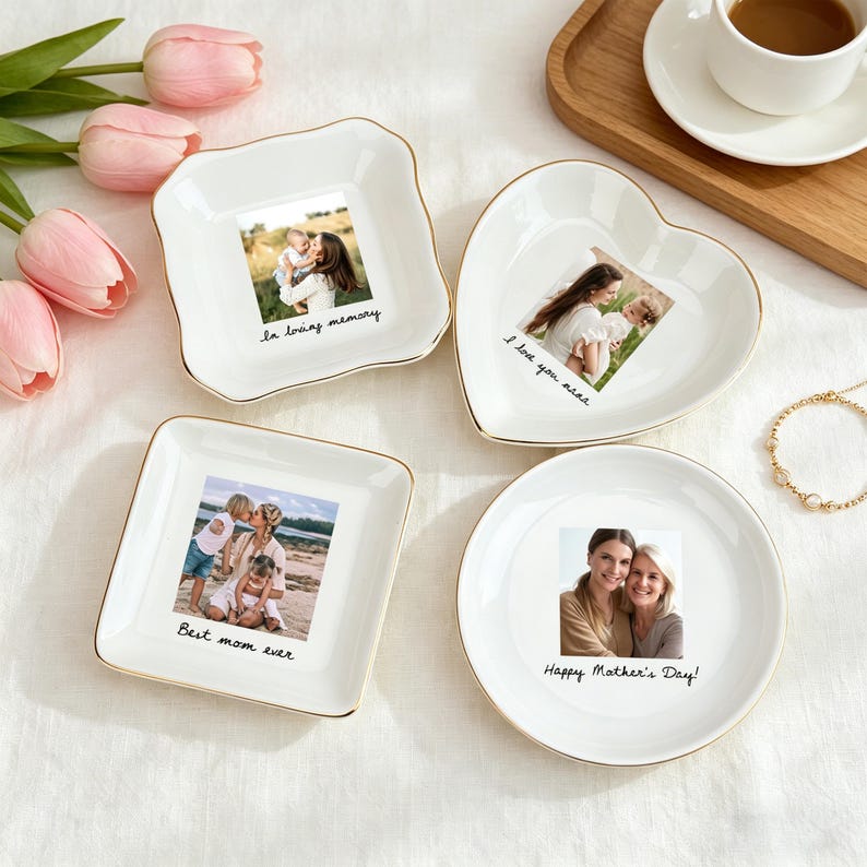 May include: Four white ceramic trinket dishes with gold rims, each featuring a photograph and a message. The dishes are square, heart-shaped, and round. Messages include "in loving memory," "I love you mom," and "Happy Mother's Day!"