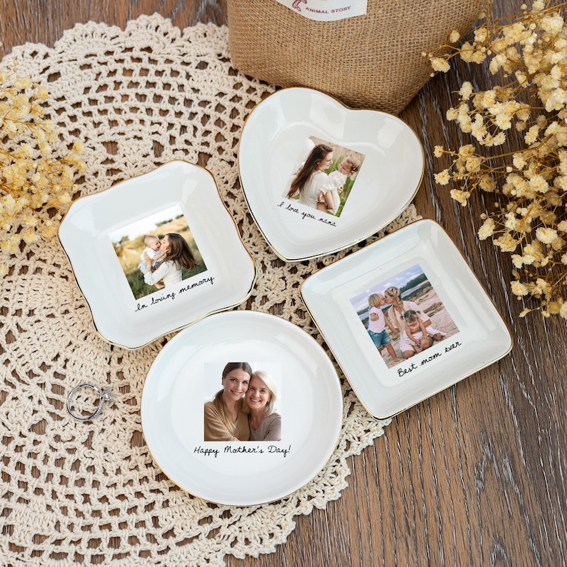 May include: Four white ceramic trinket dishes in various shapes, each with a gold rim and a photograph. The dishes have text that reads "la loving memory", "I love you nene", "Happy Mother's Day!", and "Best mom ever".