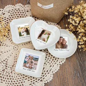 May include: Four white ceramic dishes with gold rims, each featuring a photograph and a handwritten message. The messages include "In loving memory," "I love you nana," "Happy Mother's Day!," and "Best mom ever."