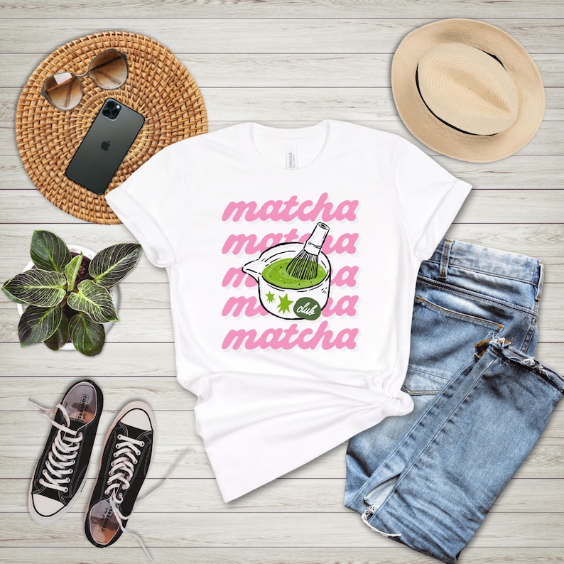 White matcha club shirt flat lay with jeans and casual accessories, cute tea lover graphic tee for coffee shop and everyday outfits.