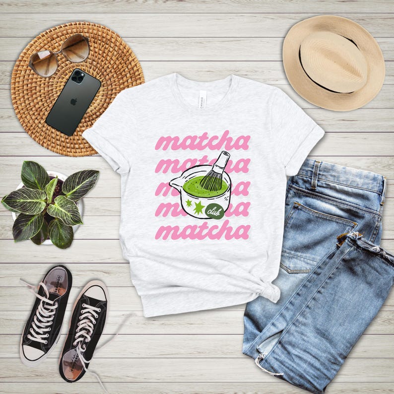Ash matcha club shirt flat lay with pink matcha lettering and green tea cup artwork, casual graphic tee for matcha lovers.