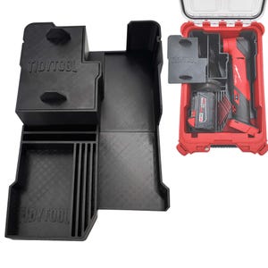 May include: Black plastic tool organiser with the text "TIDYTOOL" and a red tool case with a power tool and battery. The organiser has multiple compartments and slots for tools and accessories. The tool case is open, revealing the power tool and battery.