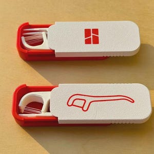 May include: Two red and white dental floss containers. Each container has a white lid with a red graphic. One lid has a square graphic, and the other has a floss pick graphic. The containers are open, revealing the floss picks.