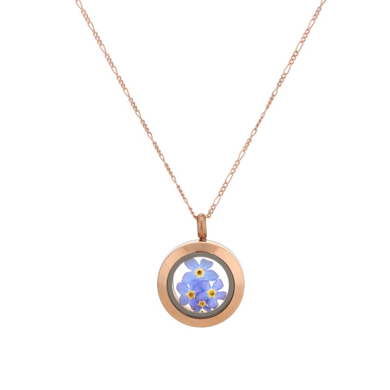Puede incluir: Un collar de oro rosa con un colgante redondo en forma de medall&oacute;n que contiene un grupo de flores de nomeolvides prensadas.